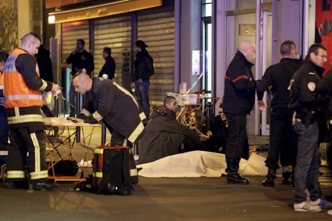 Police and paramedics assess the situation after the deadly shootings.